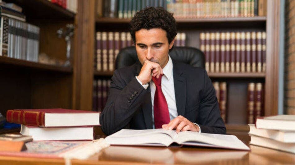 Abogado en su despacho leyendo un libro de derecho