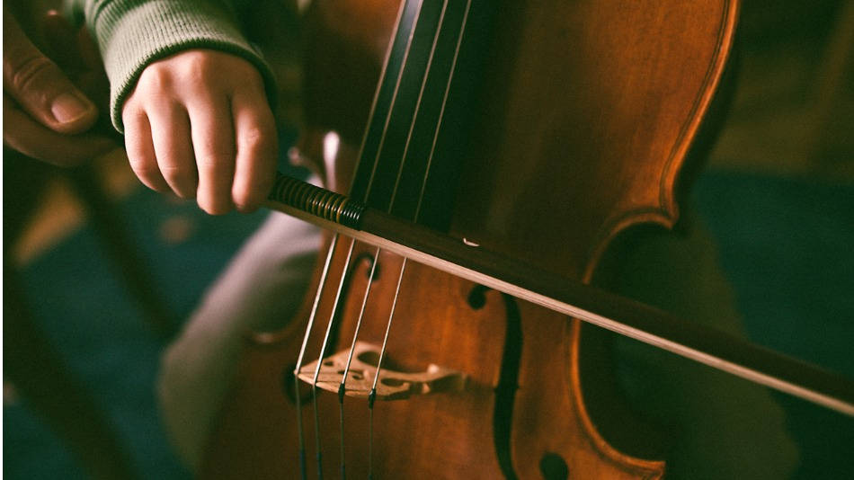 Profesor de conservatorio ayudando a un niño con una viola de gamba