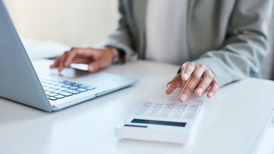 Técnico de hacienda trabajando en un ordenador y una calculadora