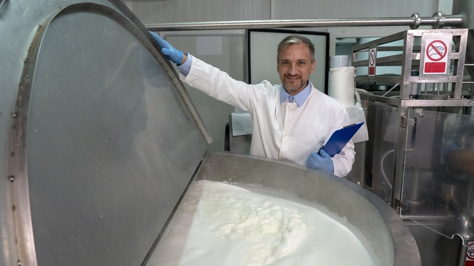 Tecnólogo de alimentos de plantas lácteas que verifica el proceso de pasteurización de la leche