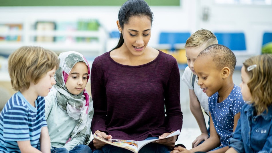 Profesora en intervención social con inmigrantes leyendo un cuento en clase