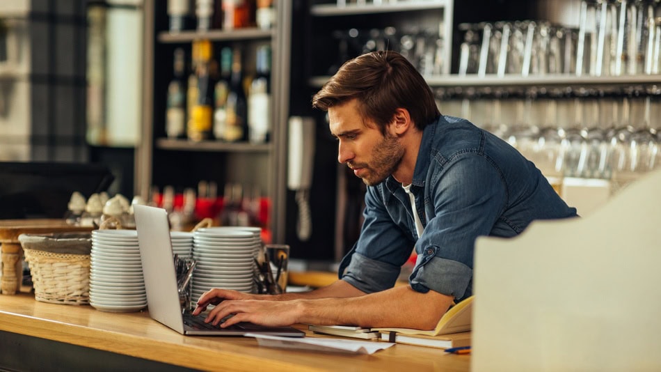 Propietario de un bar trabajando con un portátil