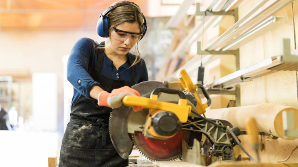 Una mujer joven trabajando con sierra circular