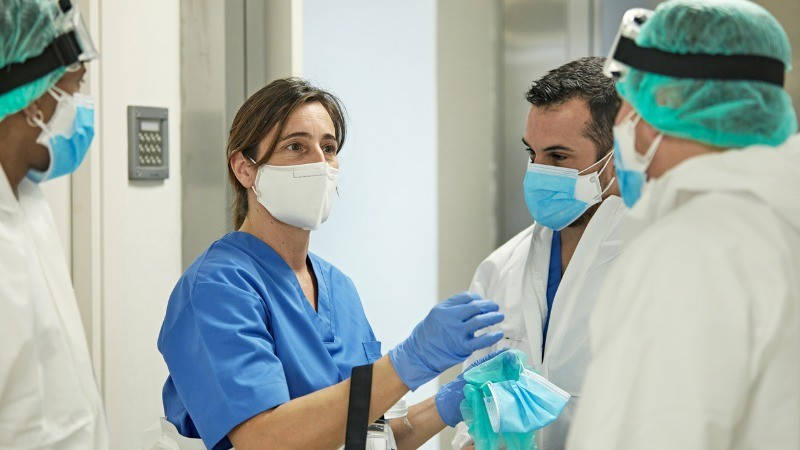 Coronavirus, COVID-19 vacuna, Enfermería; una enfermera con mascarilla y guantes lidera un equipo de sanitarios.