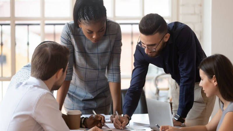 Stakeholders. Grupo de de compañeros del trabajo reunidos, apuntando ideas.