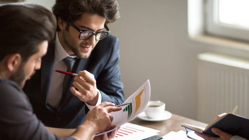 estado financiero de empresa, cuentas anuales; dos hombres viendo papeles con gráficos