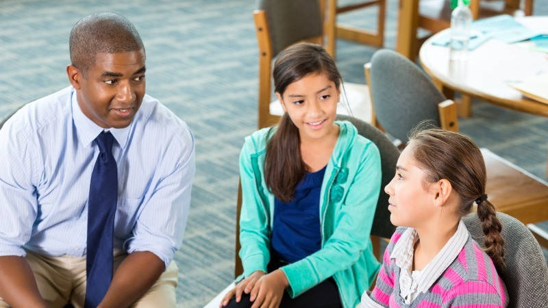 Orientación Educativa; un orientador habla con dos niñas