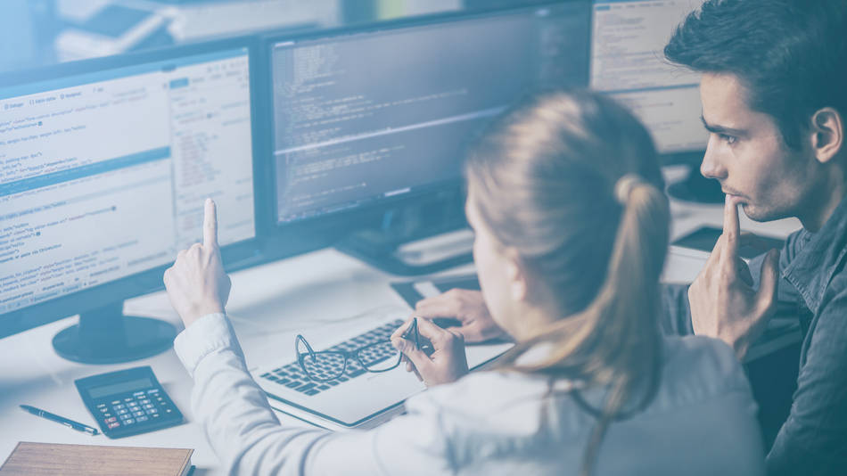 Ingeniería social, ciberseguirdad; una mujer señala a la pantalla del ordenador con un hombre al lado mirando