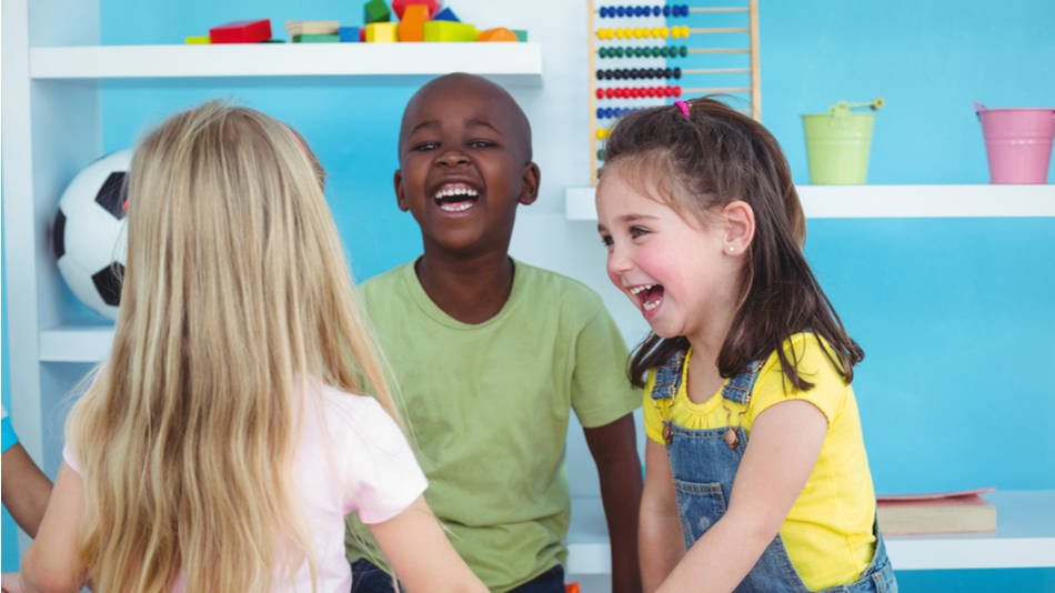 3 niños jugando juntos en el colegio riéndose