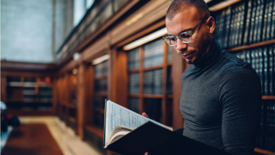 hombre leyendo en una biblioteca