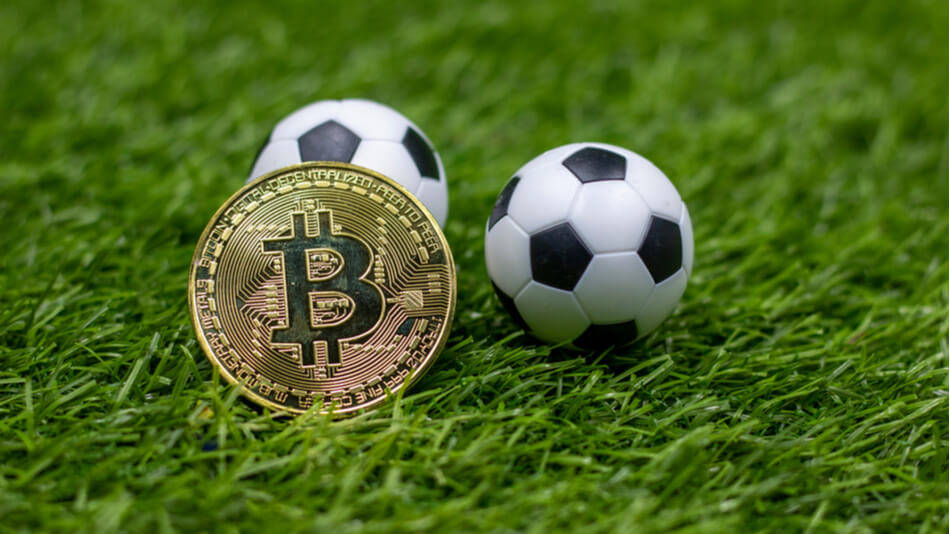 balones de futbol y criptomoneda en cesped