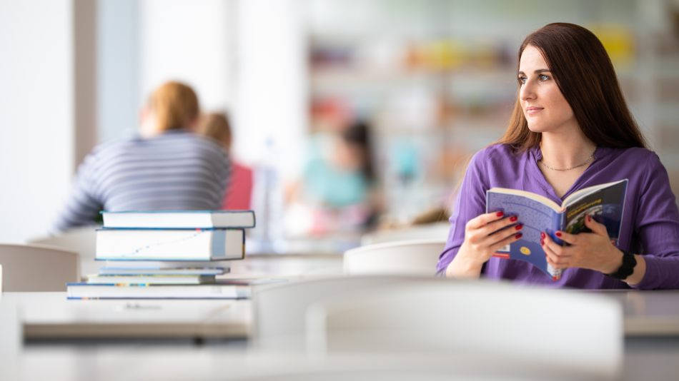 Qué máster estudiar_ graduada universitaria durante una sesión de trabajo